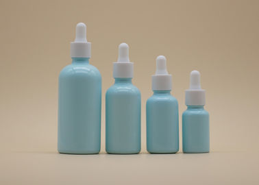 Голубая капельница эфирного масла покрытия разливает белую керамическую бутылку по бутылкам для личной заботы